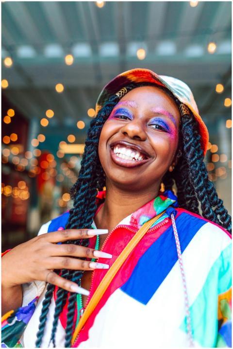 Cheerful woman with vibrant makeup and colorful cl