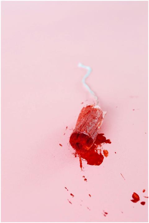 A detailed close-up of a used tampon with blood on