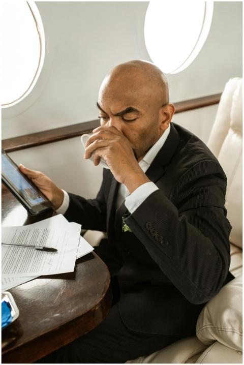 Businessman in suit sipping a drink while working