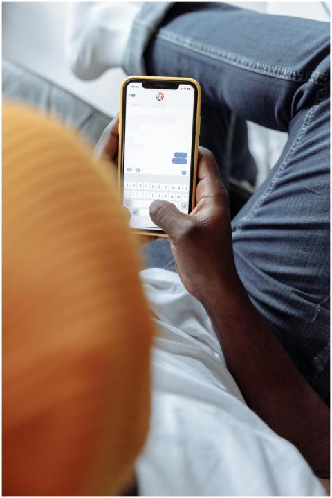 An adult using a smartphone for texting, shown in