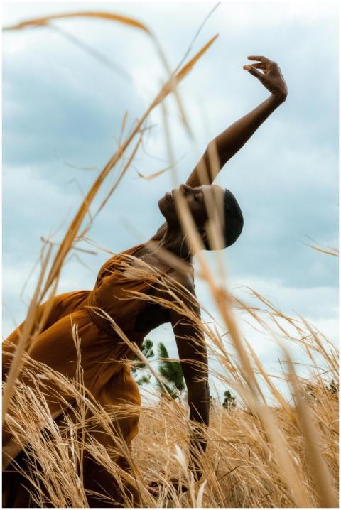 African woman gracefully dances among golden wheat