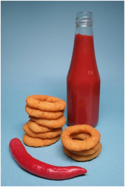 Golden onion rings paired with a spicy red sauce a