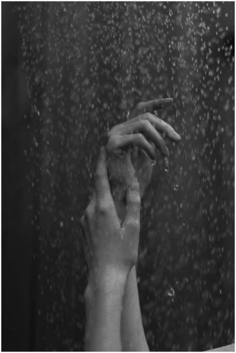 Artistic grayscale close-up of hands with water dr