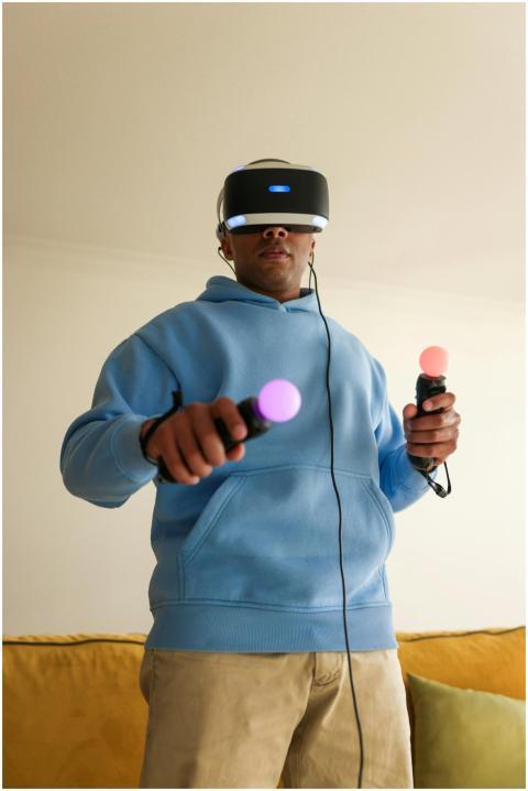 A man in a blue hoodie playing with virtual realit