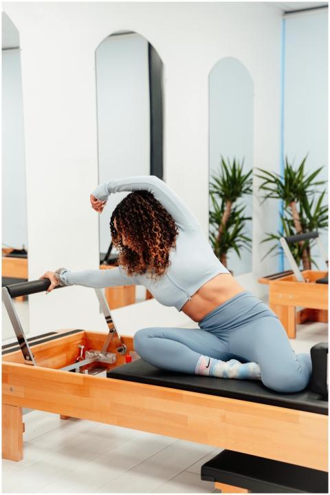 Woman practicing pilates on reformer machine, prom