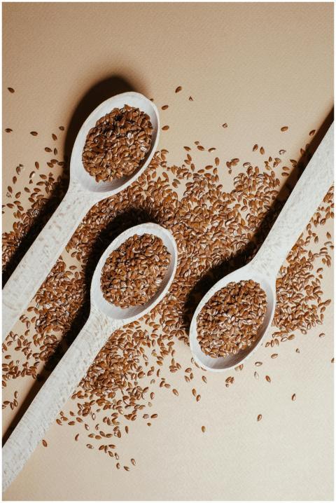 Three wooden spoons filled with flaxseeds on a tab