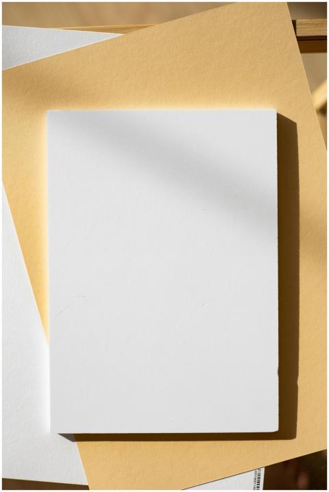 A high-angle shot of blank paper on colored surfac