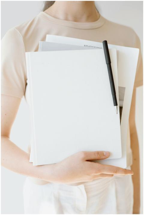 A woman holding documents with a black pen in a mi