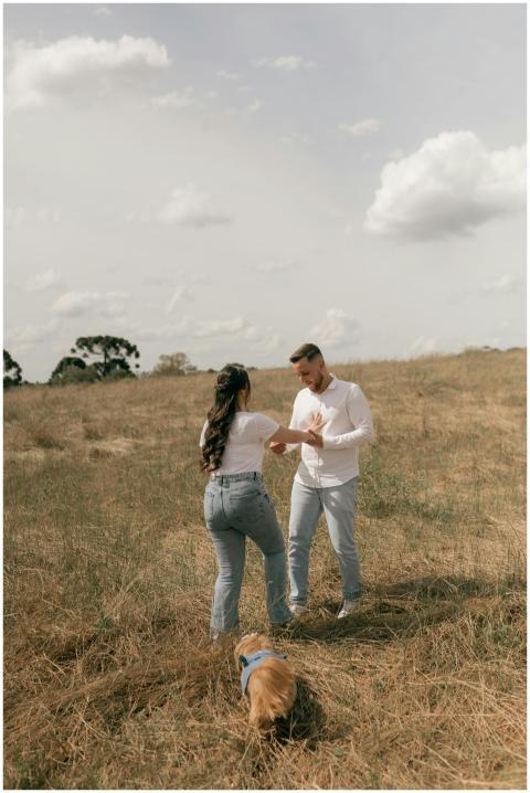 A couple enjoys a playful dance in nature with the