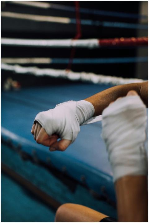 Close-up of a boxer's taped hands inside a boxing