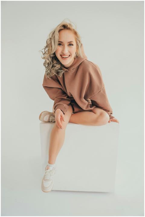 A cheerful woman with blonde curly hair posing on
