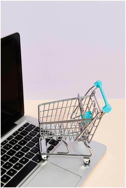 Mini shopping cart on a laptop symbolizes online s