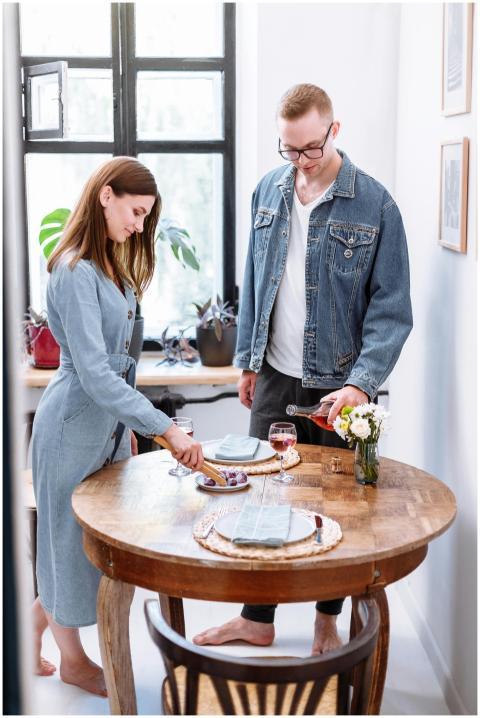 A couple in denim outfits enjoying red wine at a h