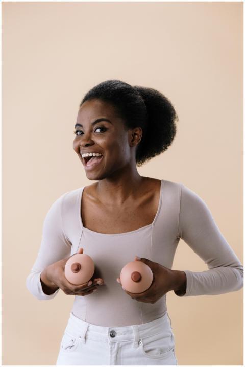 Confident woman holding breast models to promote b