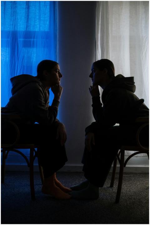 Two silhouetted figures facing each other evoke th