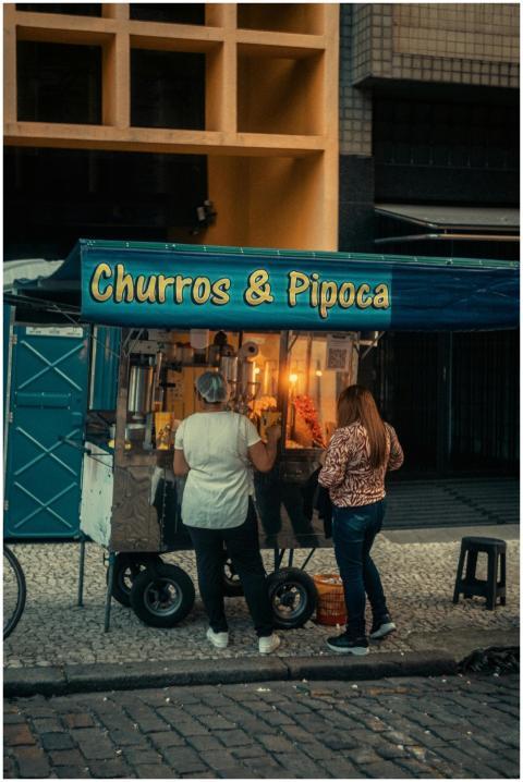 Street vendor stand offering churros and popcorn a