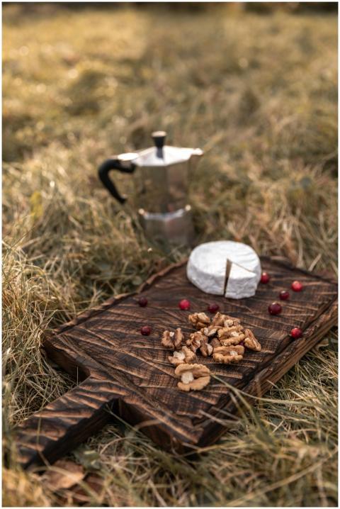Rustic outdoor picnic setup with cheese, nuts, and