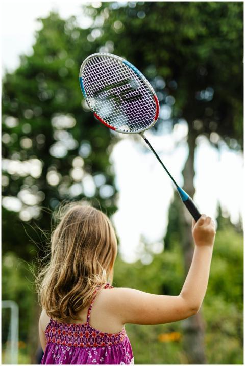 Young girl enjoys a game of badminton outdoors in