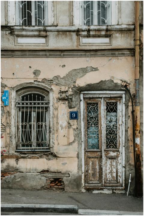A rustic, aged facade of a building in Tbilisi wit