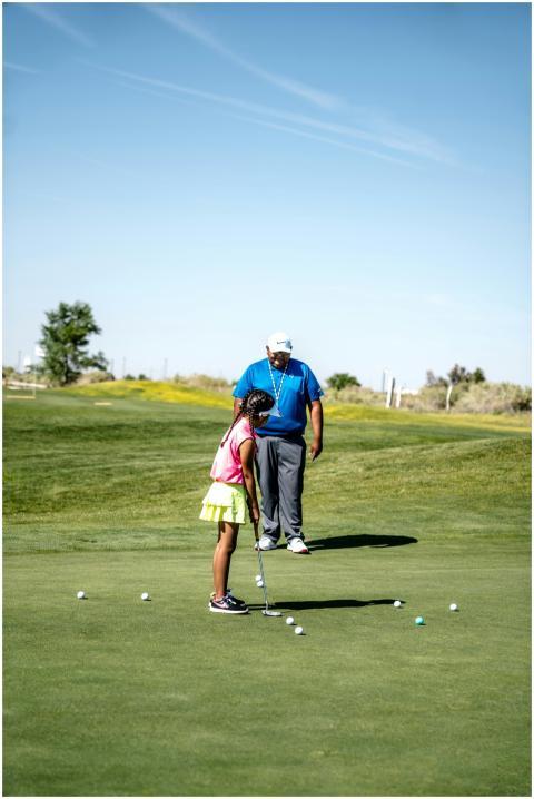 A girl practicing golf under sunny skies with her
