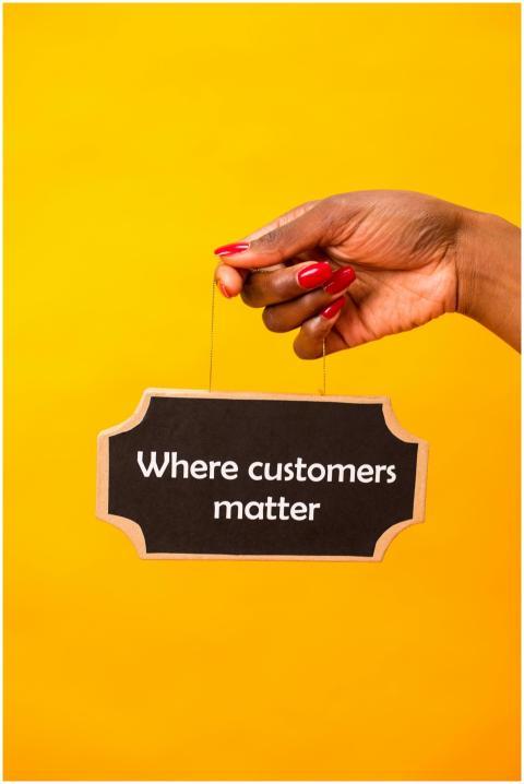 Hand holding a sign with 'Where customers matter'