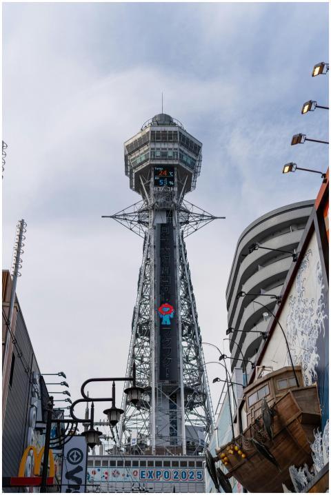 Tsutenkaku Tower in Osaka stands tall under a clea