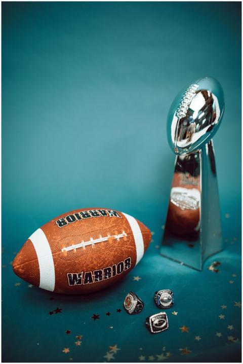 Football trophy and rings with a football on blue