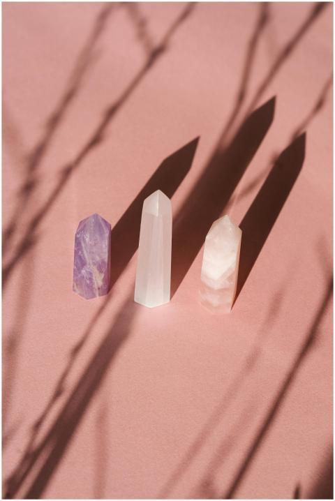 Set of three crystals casting shadows on pink back