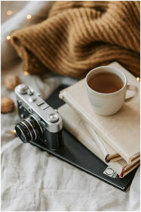 A cozy setup with a vintage camera, books, and a c