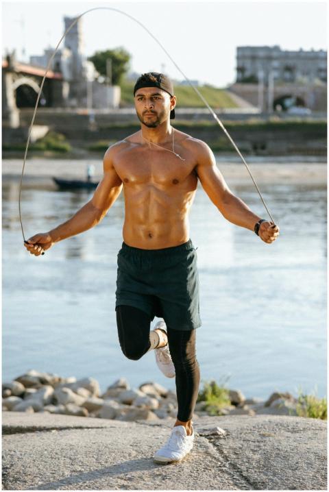 Fit man exercising with a jump rope outdoors near