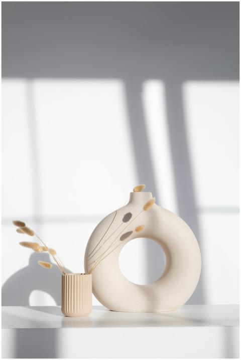 Soft focus minimalist display of beige ceramic vas