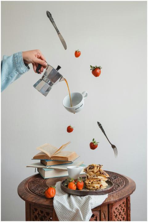 Creative composition of floating coffee, pancakes,