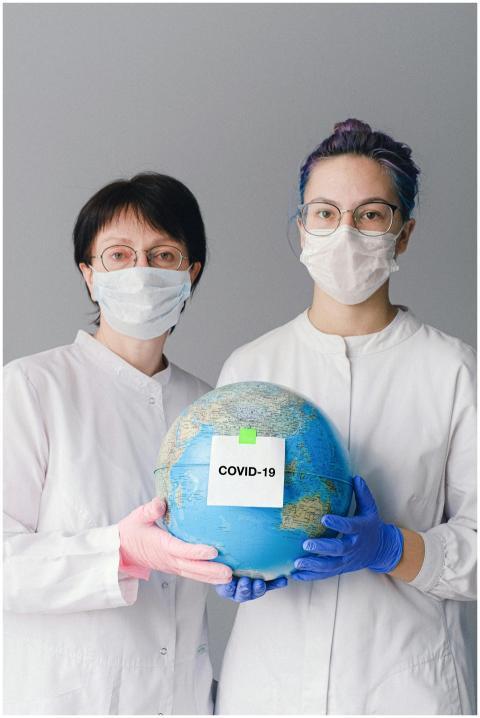 Two healthcare professionals in masks and gloves h