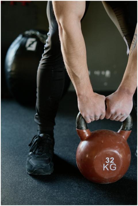 Athletic male lifting a kettlebell for strength tr
