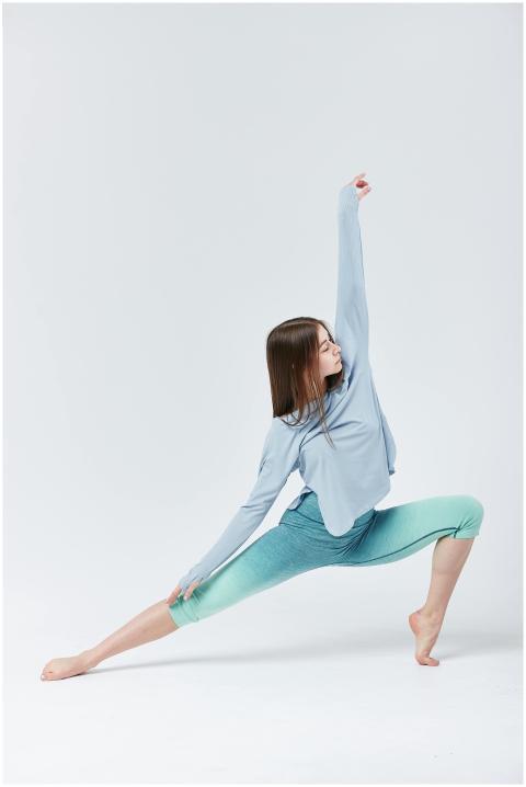 Young woman in a yoga pose on a white background w