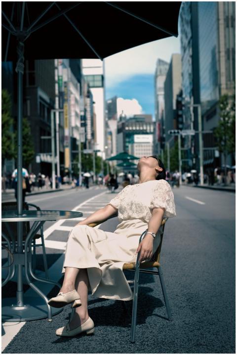 A woman enjoys a sunny day in Ginza, Tokyo, relaxi