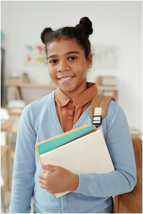 Smiling young student with a backpack and notebook