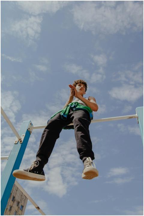 Teen balancing on monkey bars, capturing adventuro