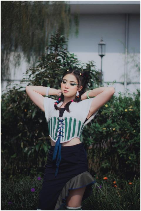 Fashionable woman poses confidently in a garden se