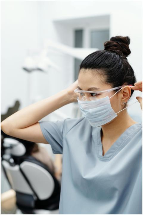 Asian woman in a dental office adjusting protectiv