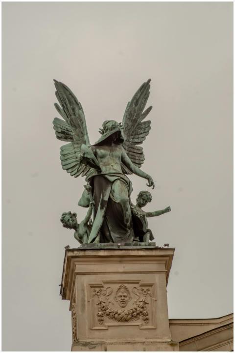 Bronze statue of an angel with children atop a bui