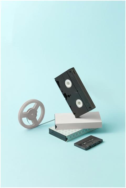 Vintage VHS and cassette tape styled on a pastel b