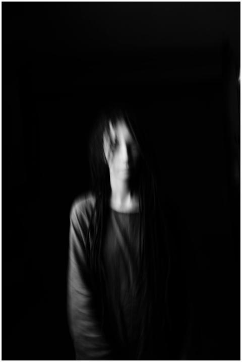 Haunting blurred portrait of a woman on a dark bac