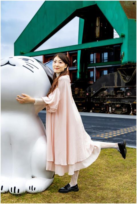 Young woman in pink dress embracing a large cat sc