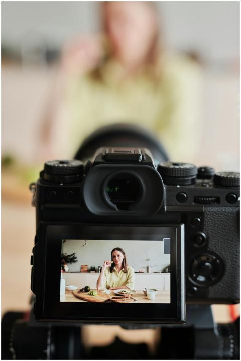 Close-up of a woman filming a cooking vlog in her