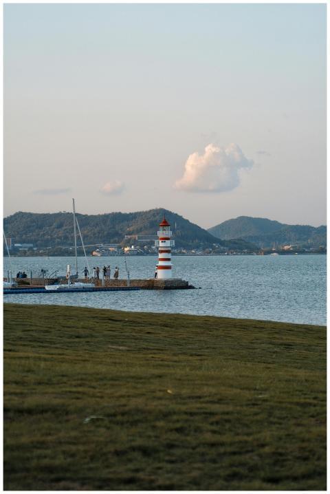 A peaceful lighthouse on the coast with distant mo