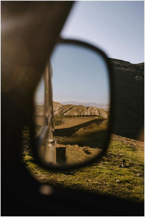 Reflection of mountainous landscape in car side mi