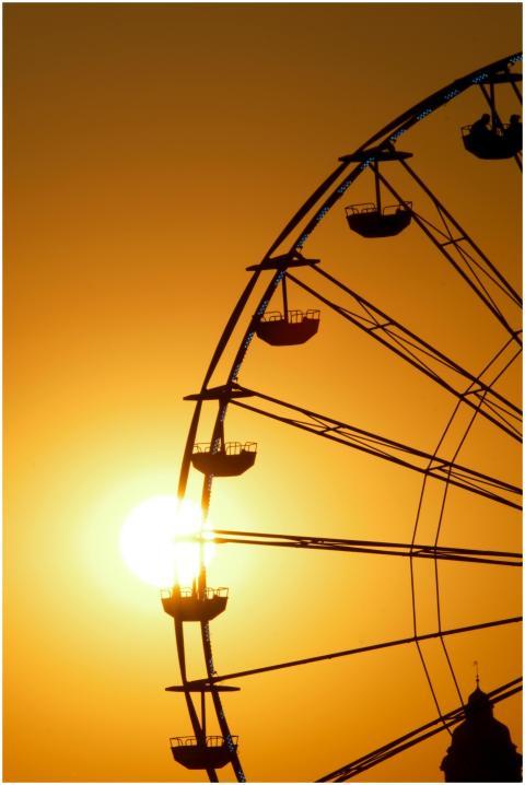 Dynamic silhouette of a Ferris wheel against a vib