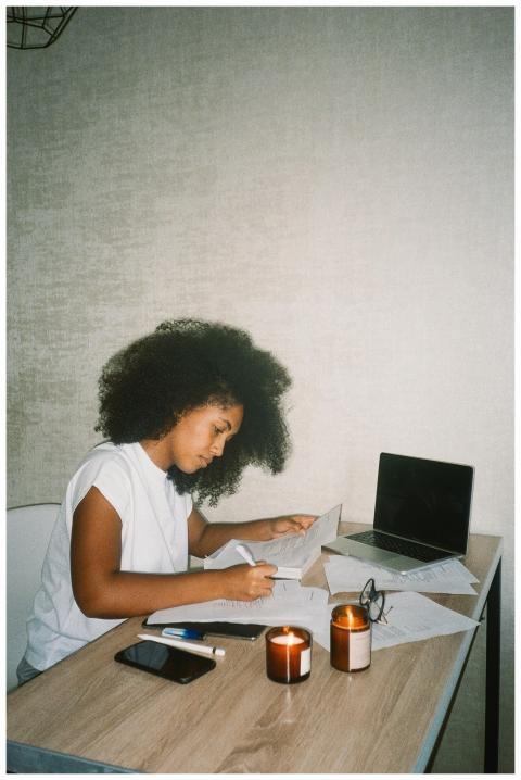 A woman working with documents at home by candleli