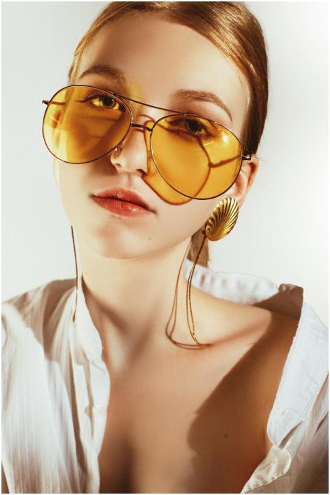 Chic portrait of a woman in yellow sunglasses and
